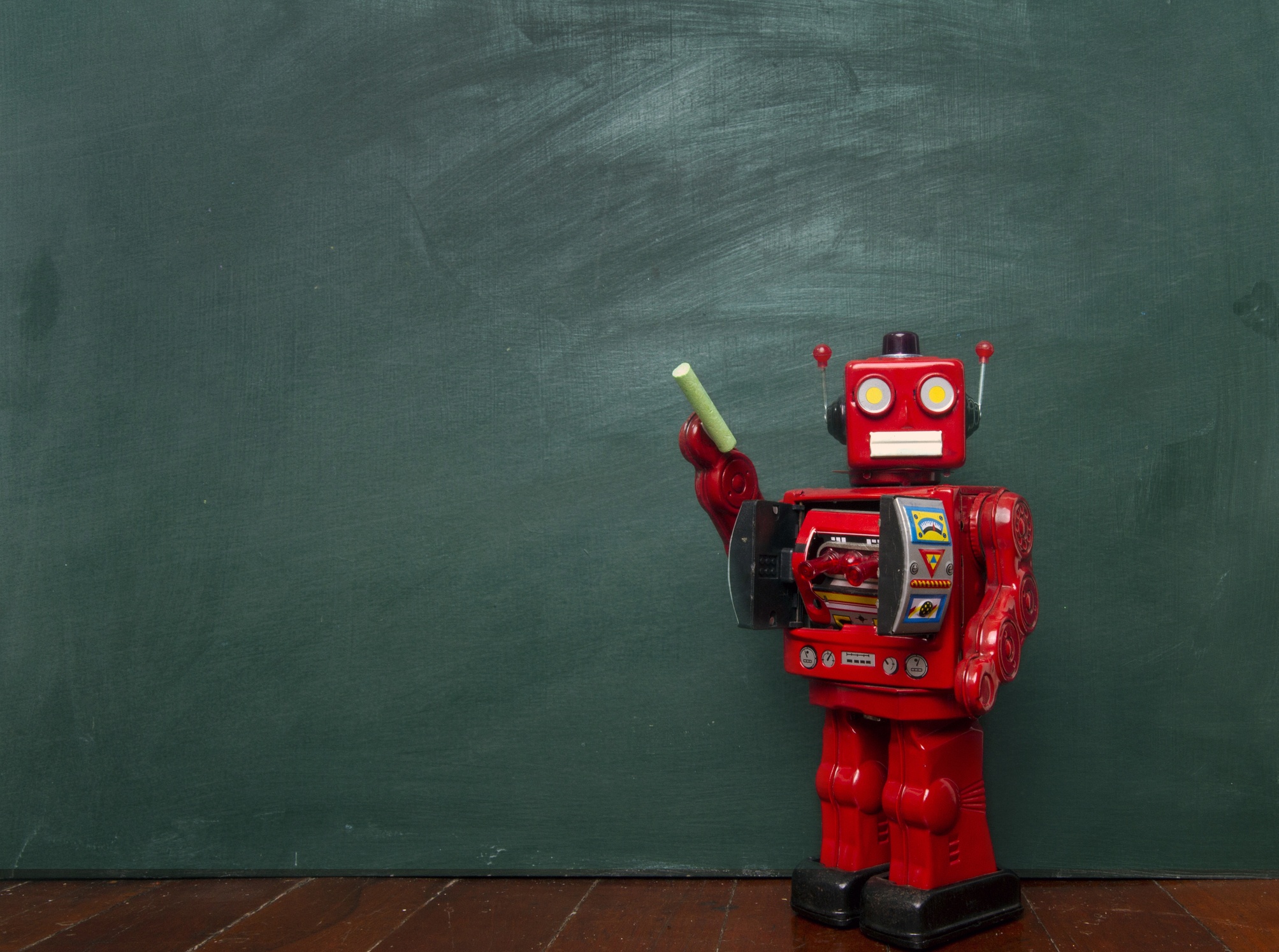 A red 1950's style robot stands before a blank chalk board, holding a piece of chalk, ready to write - Bee Digital Marketing