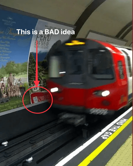 A picture of a tube rushing through a station. There is a circle around a QR code on the advert, with an arrow pointing to it and words saying "This is a BAD idea"