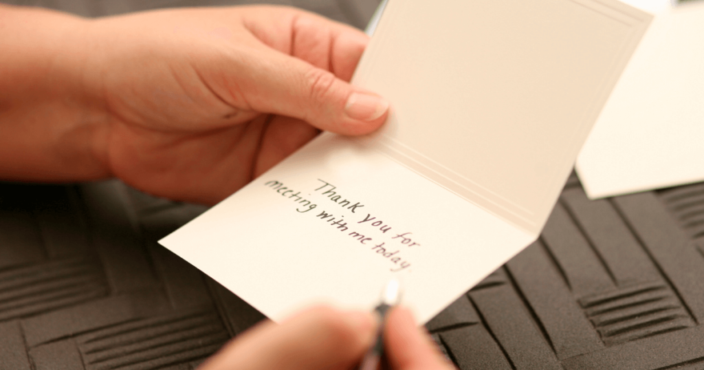 Hands opening a handwritten note card. Text: thank you for meeting with me today
