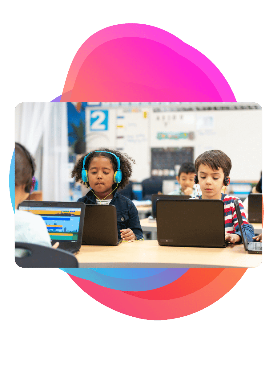 Primary age children working with headphones and laptops - Bee Digital marketing agency